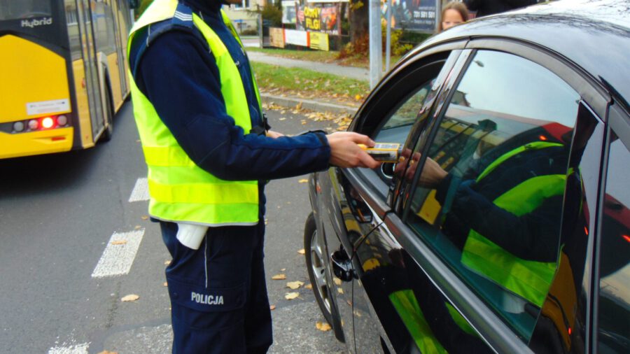 KPP Oświęcim. Policjant dokonuje badania trzeźwości kierowcy
