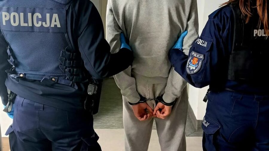 nastolatek w kajdankach z 2 policjantami po bokach