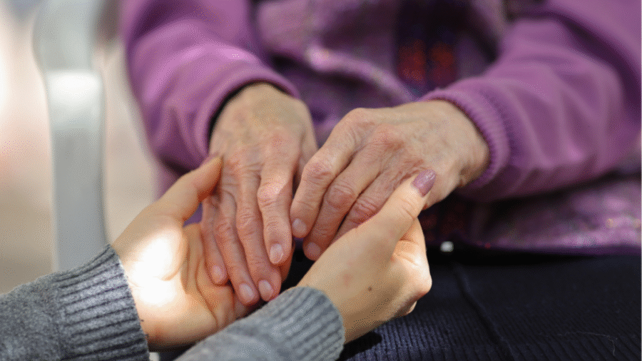 młoda kobieta trzyma ręce seniorki