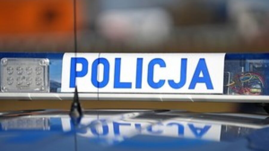Sygnały świetlne i dźwiękowe na dachu pojazdu. Na białym tle niebieski napis Policja, po prawej i lewej stronie światła